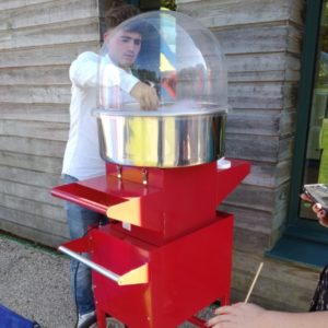 Homme faisant une barbe à papa avec une machine à papa