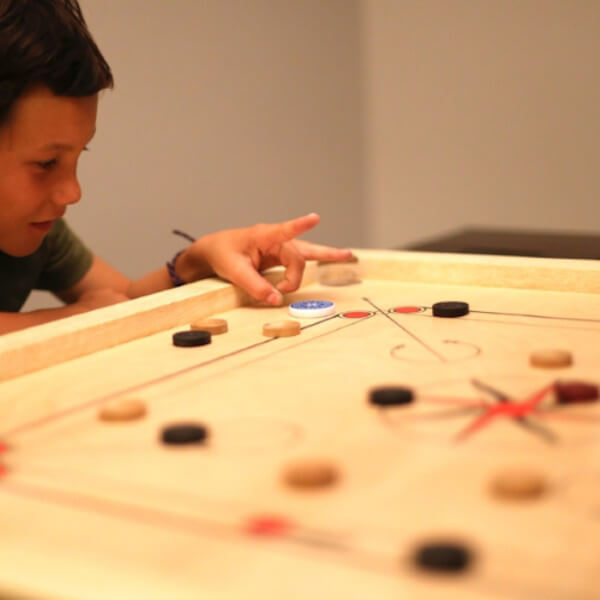 Billard indien carrom avec un enfant qui joue avec les doigts