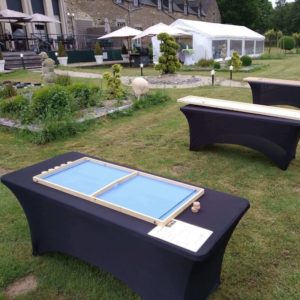 Tables 180 cm avec housses noires en lycra et jeux dessus