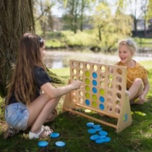 2 filles jouant au puissance 4 en bois dans la nature