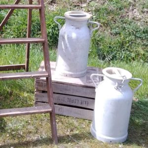 Décor avec deux pots à lait, une caisse en bois et un escabeau