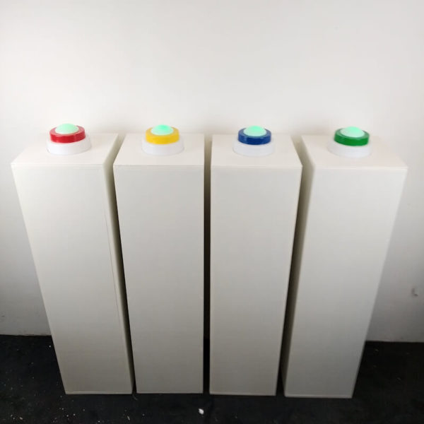 Buzzer Totem de 4 couleurs différentes posé sur des présentoirs pour jouer au blindtest