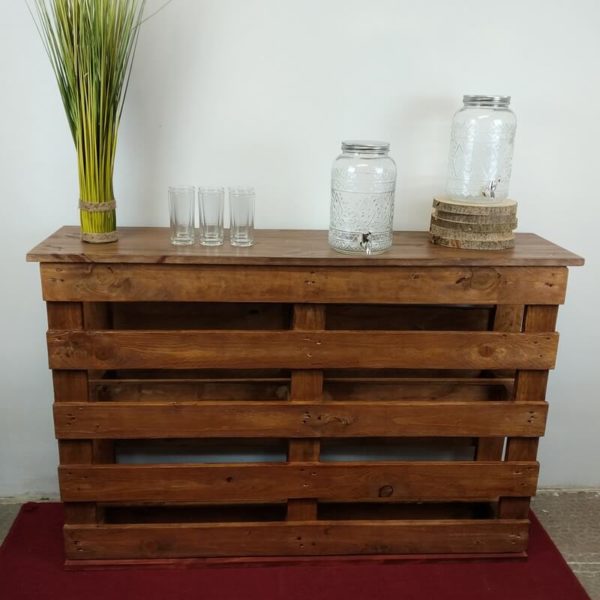 Mini bar en palettes de bois avec plante verte, verres à jus et fontaines