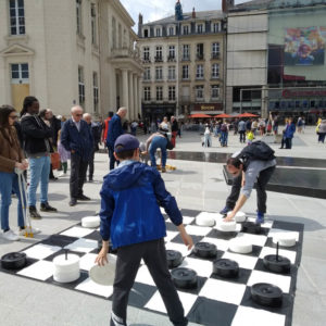 Plusieurs personnes jouant au jeu de Dames Géantes en location