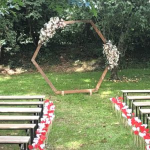 Arche hexagonale en bois lors d'une cérémonie laique avec des bancs et des coeurs